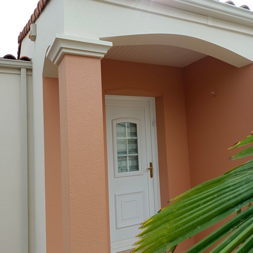 Entrée de maison avec façade ocre et encadrements blancs peints