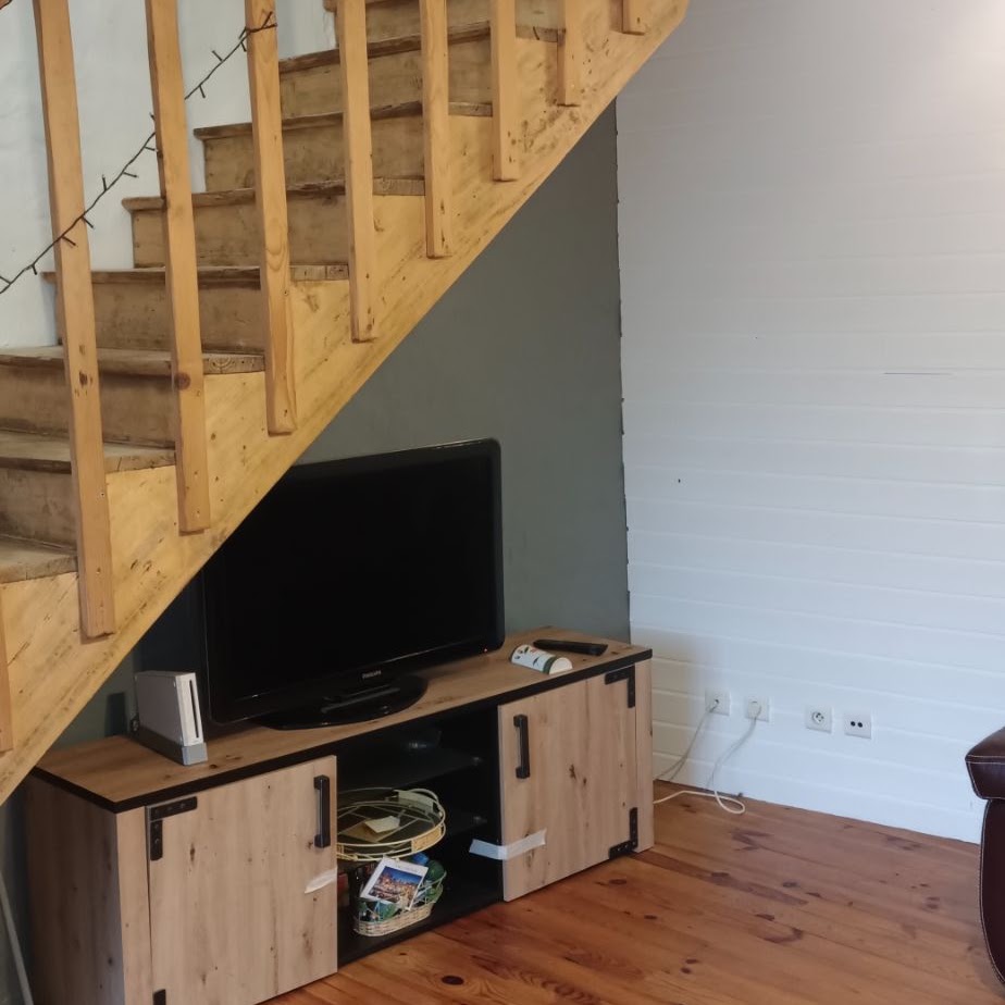 Mur gris peint sous un escalier en bois et meubles intégrés